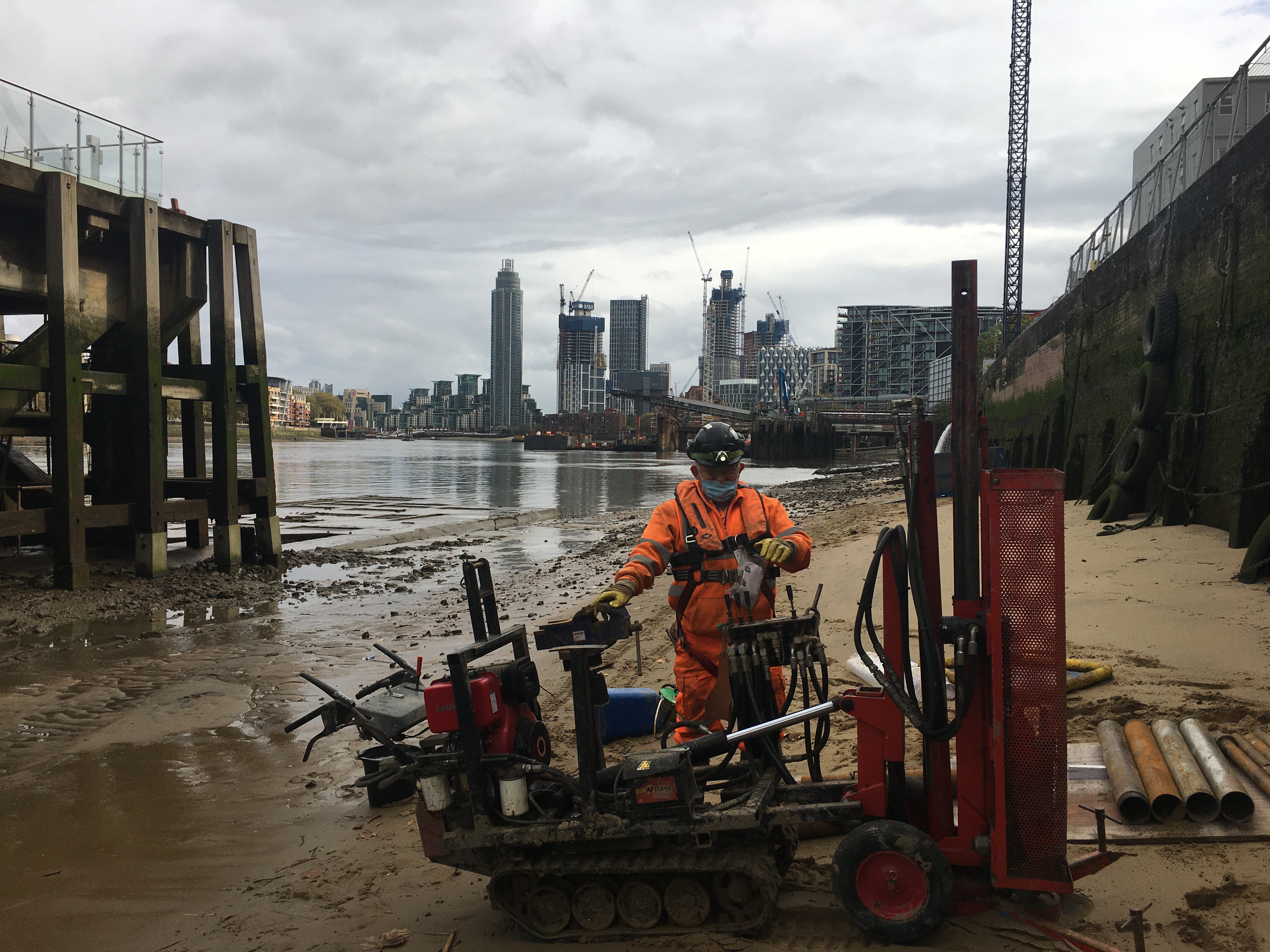 Drilling operative completing a window sample borehole on the bank of the Thames